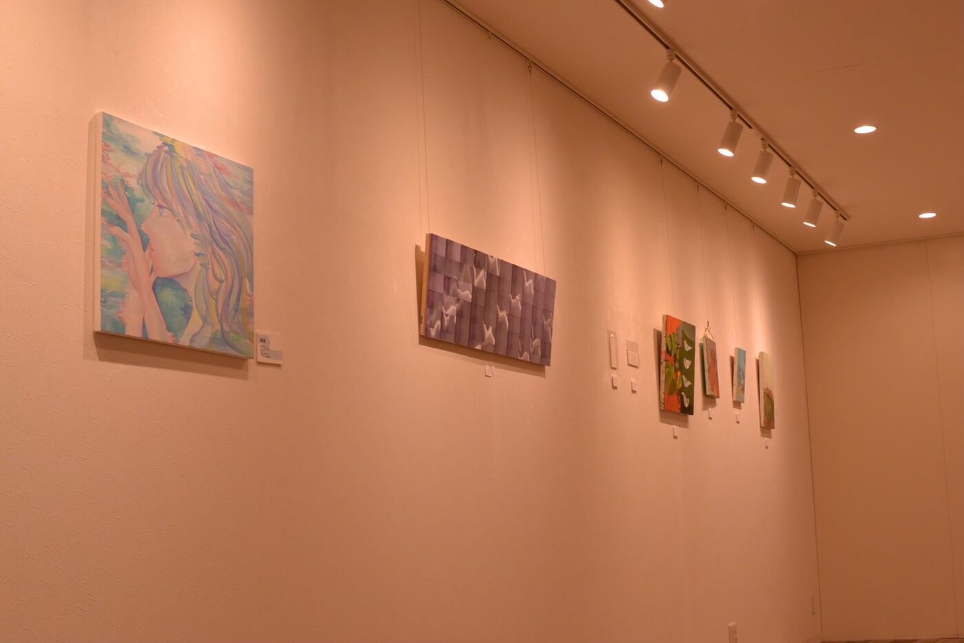 前回展示の会場風景。あたたかな照明の下に絵画作品が並ぶ